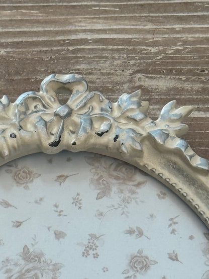 Cornice ovale bianca con decorazione a fiocco